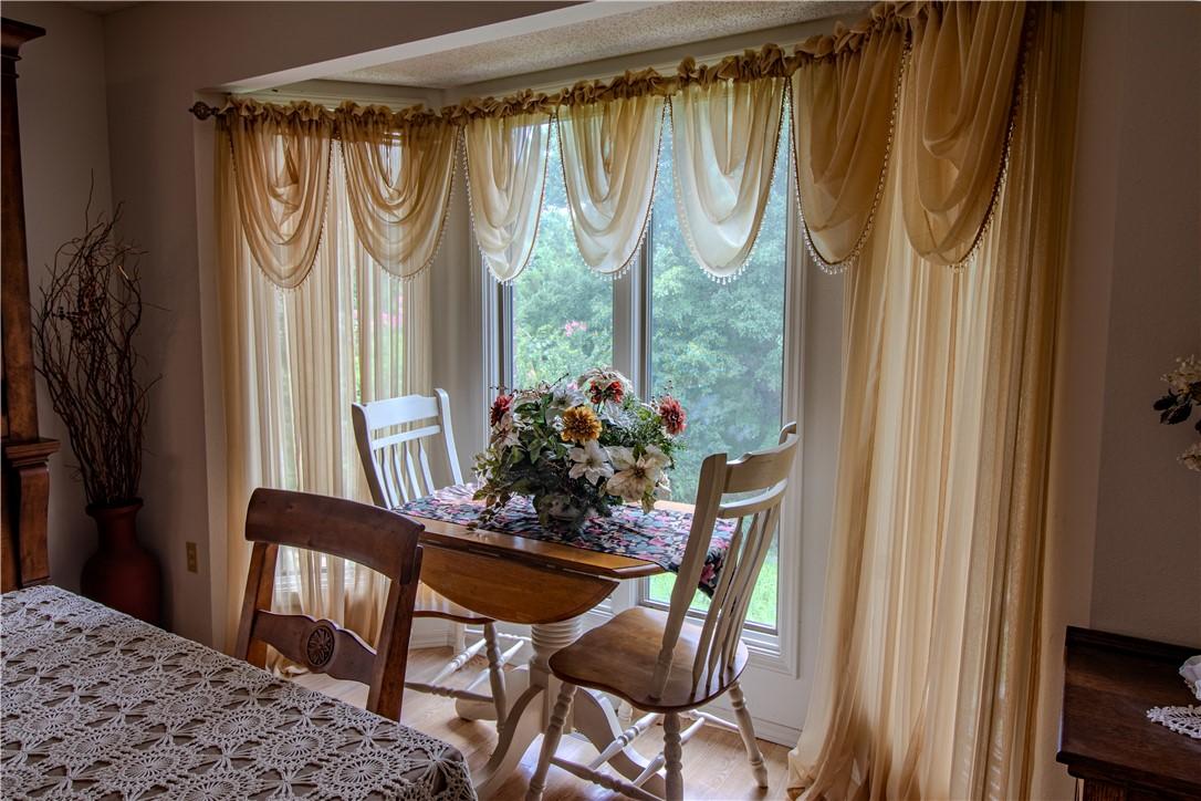 Image 2: Bay window with sheer draping, wood-finish floorin