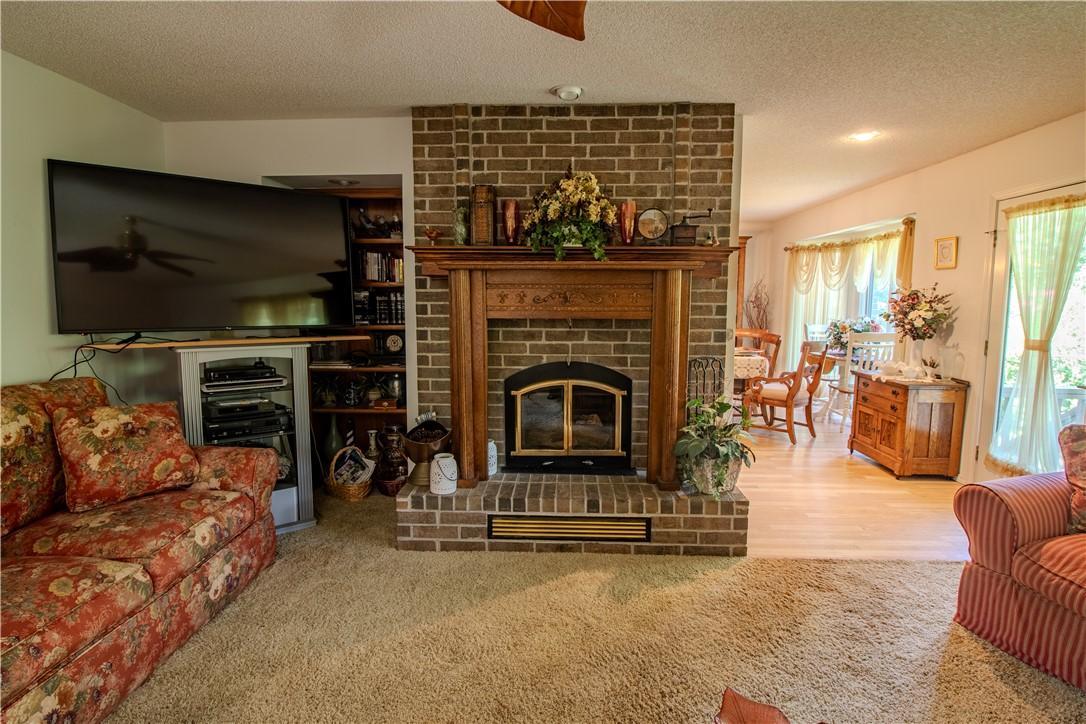Image 4: Brick fireplace featuring a wood mantel