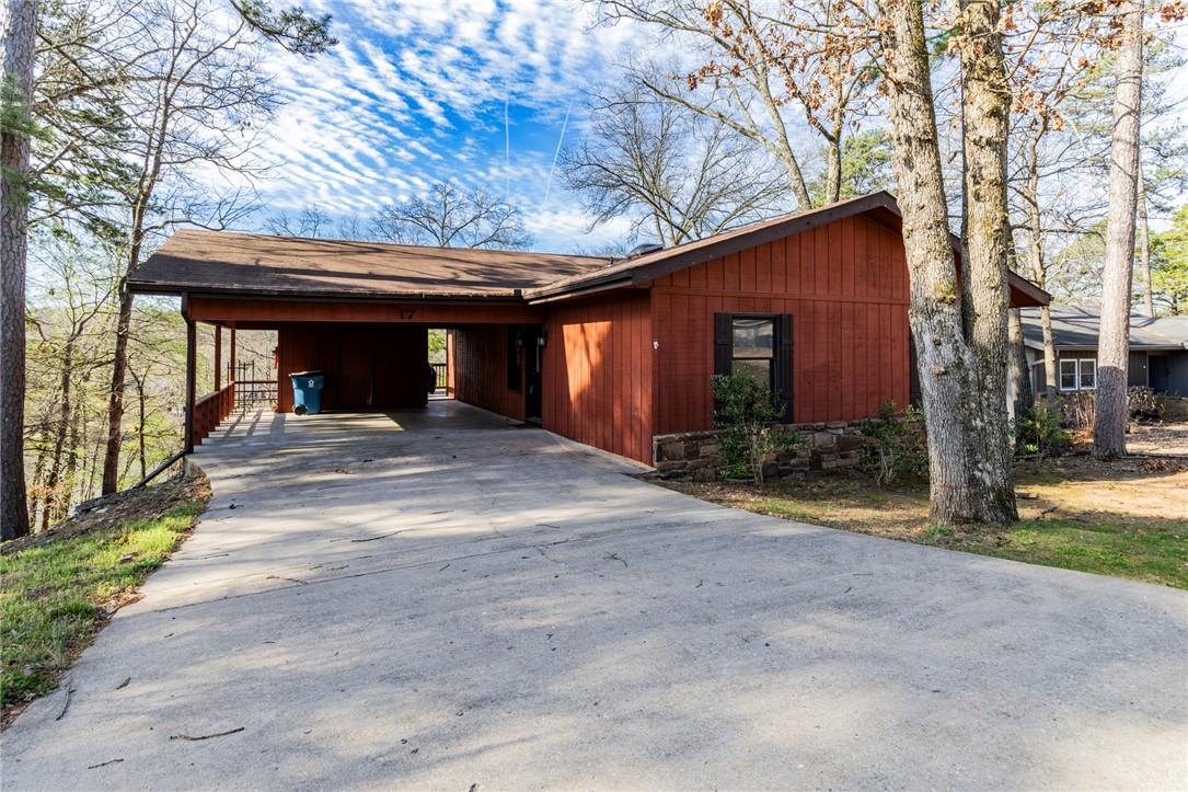 Image 3: View of front facade with driveway and a carport