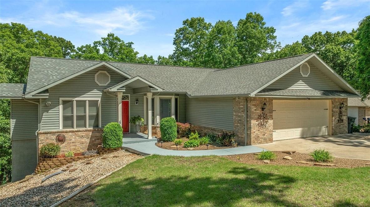 Image 4: Front exterior featuring a red entry door, gray si