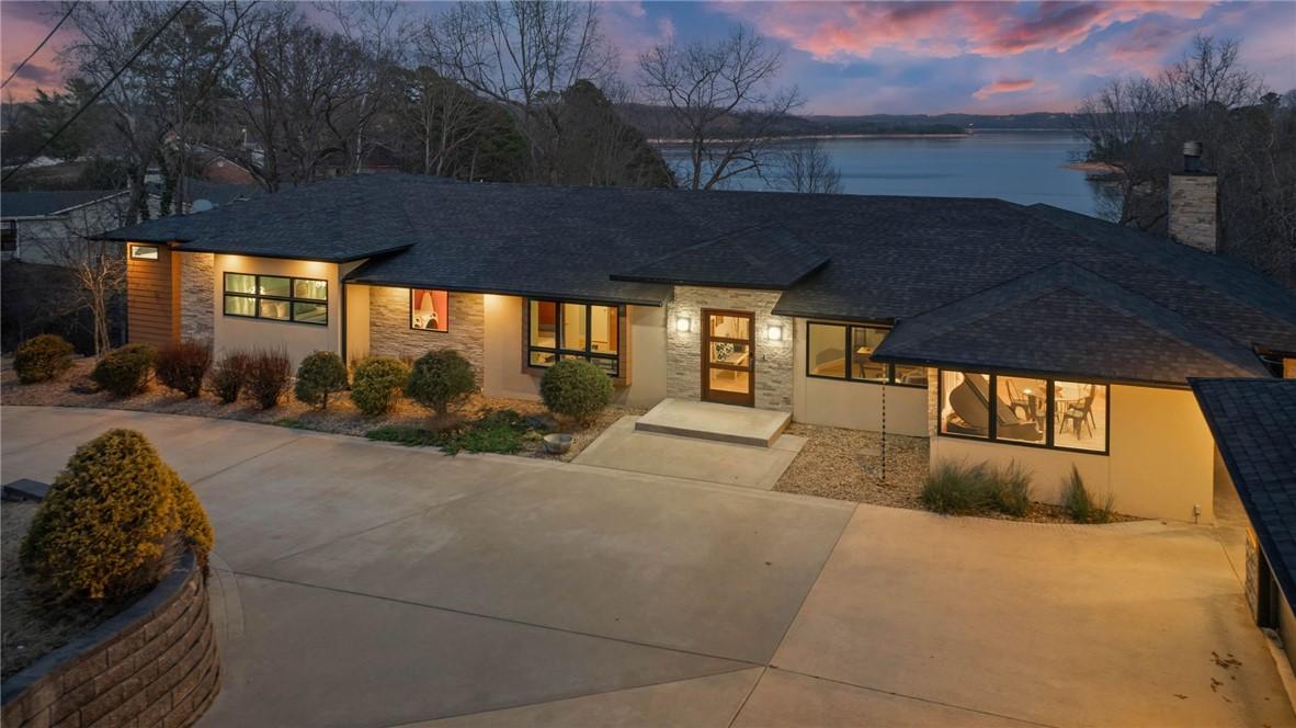 Image 1: View of front facade with a shingled roof, stucco