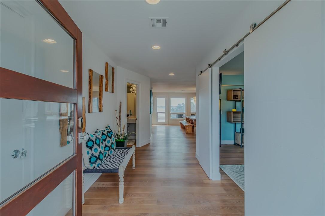 Image 4: Hall featuring a barn door, light wood-type floori