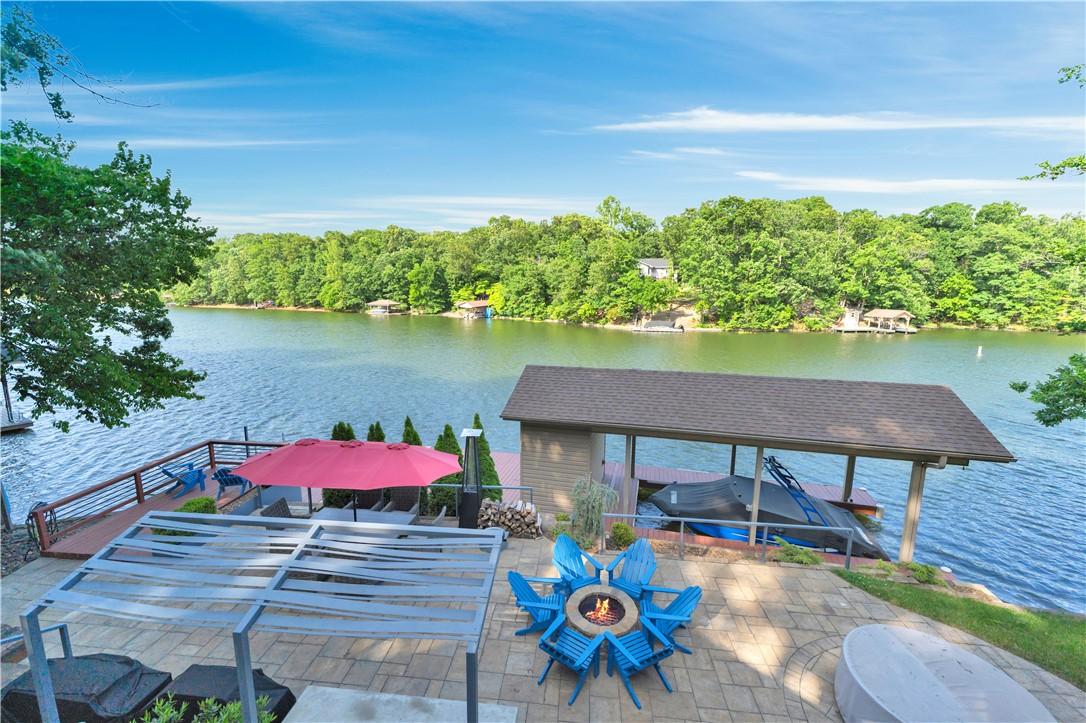 Image 4: Expansive waterfront patio featuring a fire pit ar