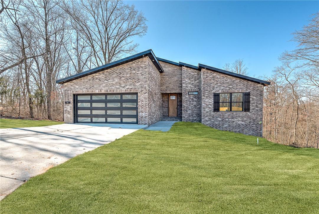 Image 1: View of front of property with brick siding, concr