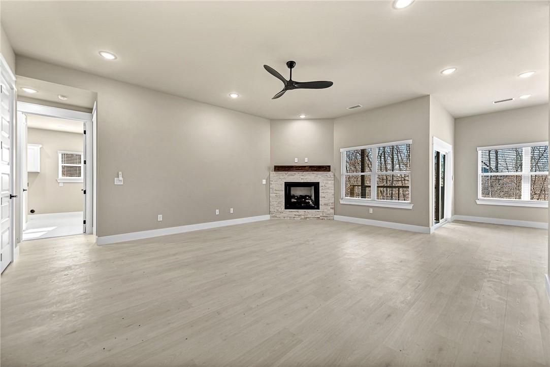 Image 2: Unfurnished living room featuring a fireplace, lig