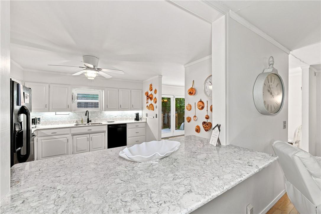 Image 3: Kitchen featuring white cabinetry with under-cabin