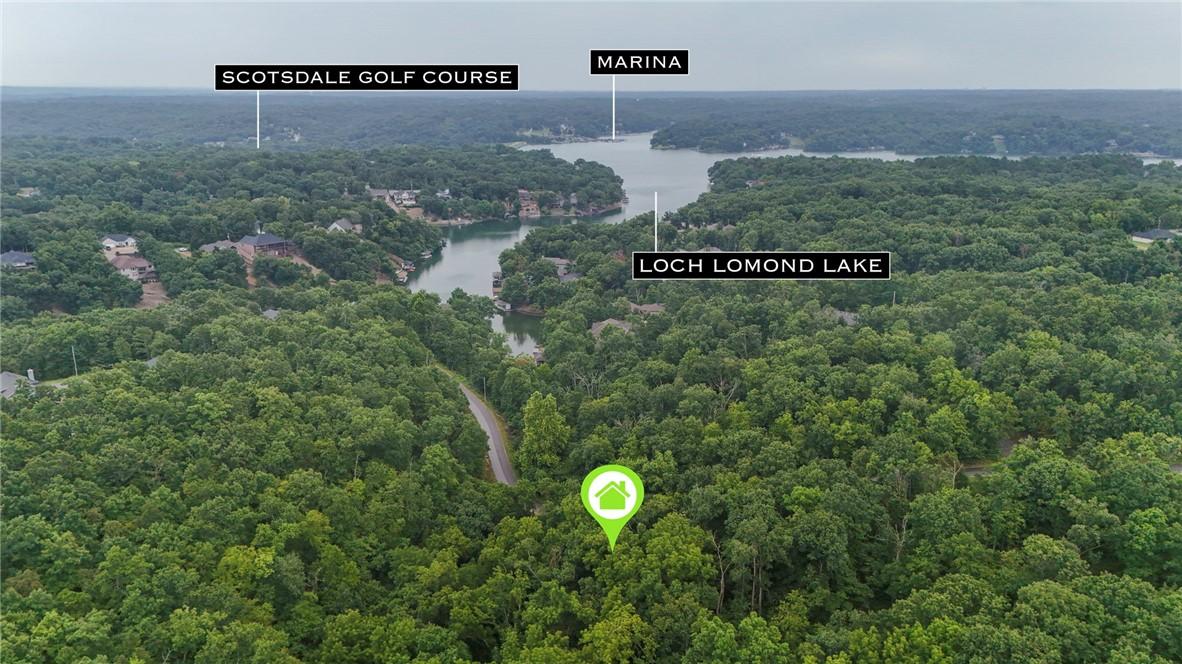 Image 1: Wooded lot with road access, offering proximity to