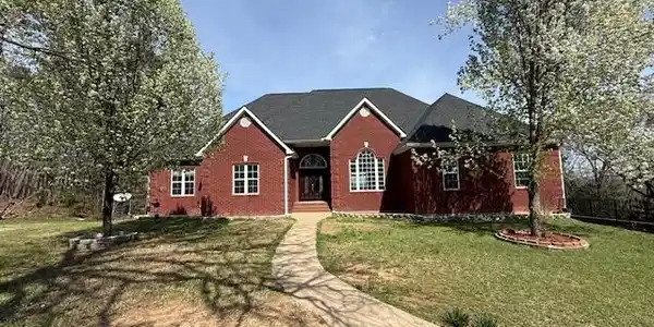 Image 3: Ranch-style home with a front yard and brick sidin