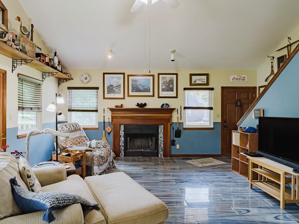 Image 4: Living area featuring a fireplace with a wood mant