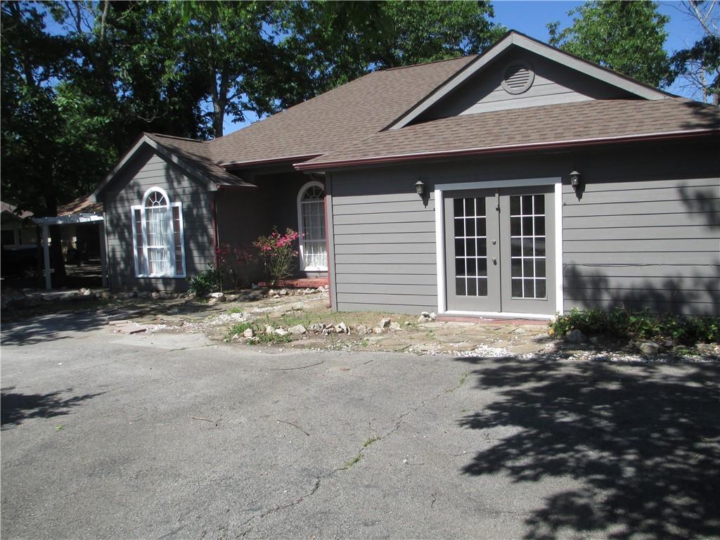 Image 4: Gray siding exterior featuring a brown shingle roo