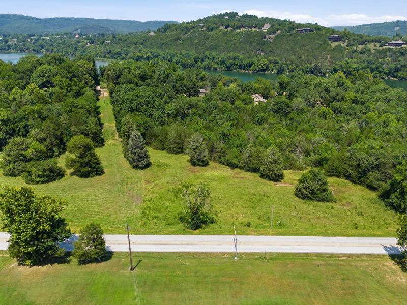 Image 1: Expansive land parcel featuring direct road fronta