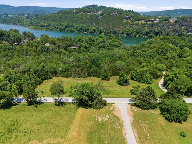 Image 2: Expansive land parcel featuring a paved road, grav