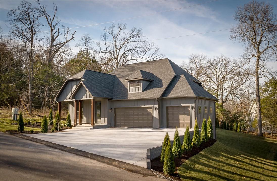 Image 2: View of front facade featuring concrete driveway,