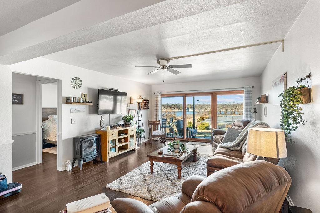 Image 2: Living room with a ceiling fan, dark wood finished