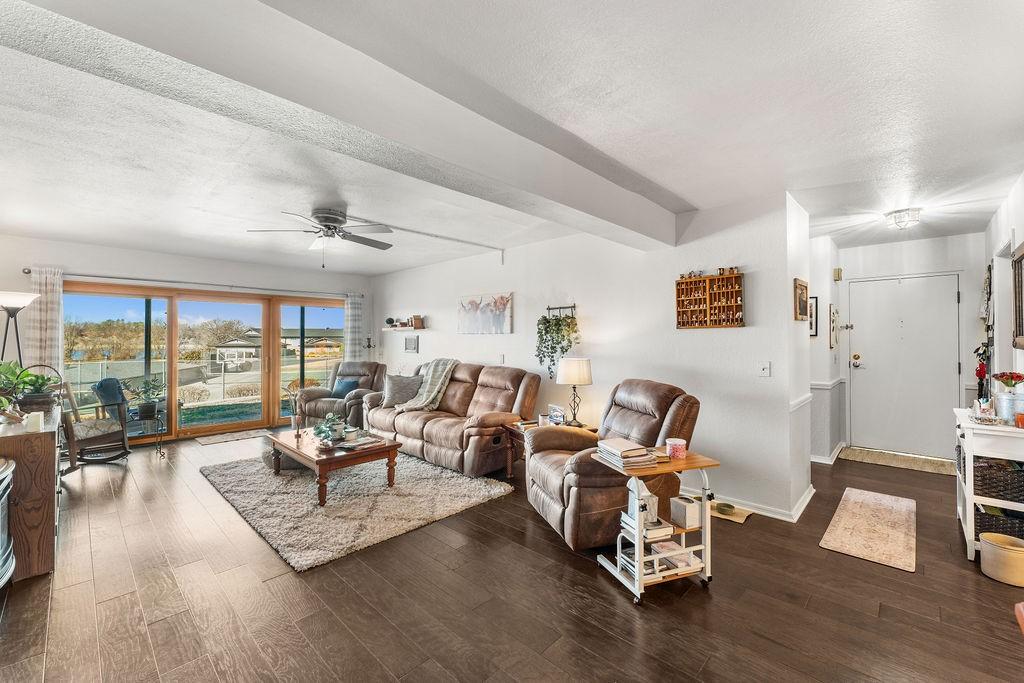 Image 3: Living room with ceiling fan, a textured ceiling,