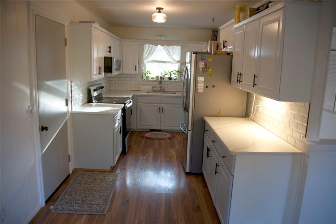 Image 3: Kitchen featuring white cabinetry, stainless steel