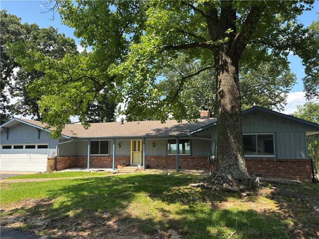 Image 4: Ranch-style exterior with blue siding and brick ac