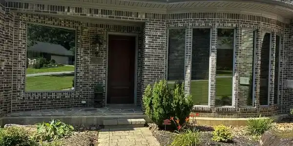 Image 2: Brick exterior with a dark wood entry door, featur