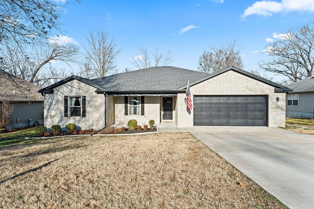 Image 1: Ranch-style house with an attached garage, a porch
