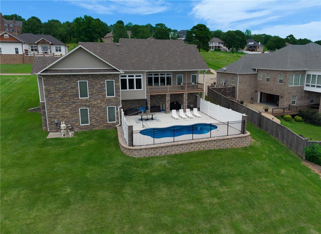 Image 2: Rear exterior featuring a freeform swimming pool,