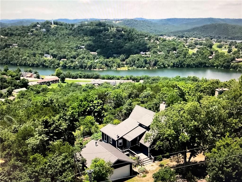 Image 3: Elevated property surrounded by mature trees, feat