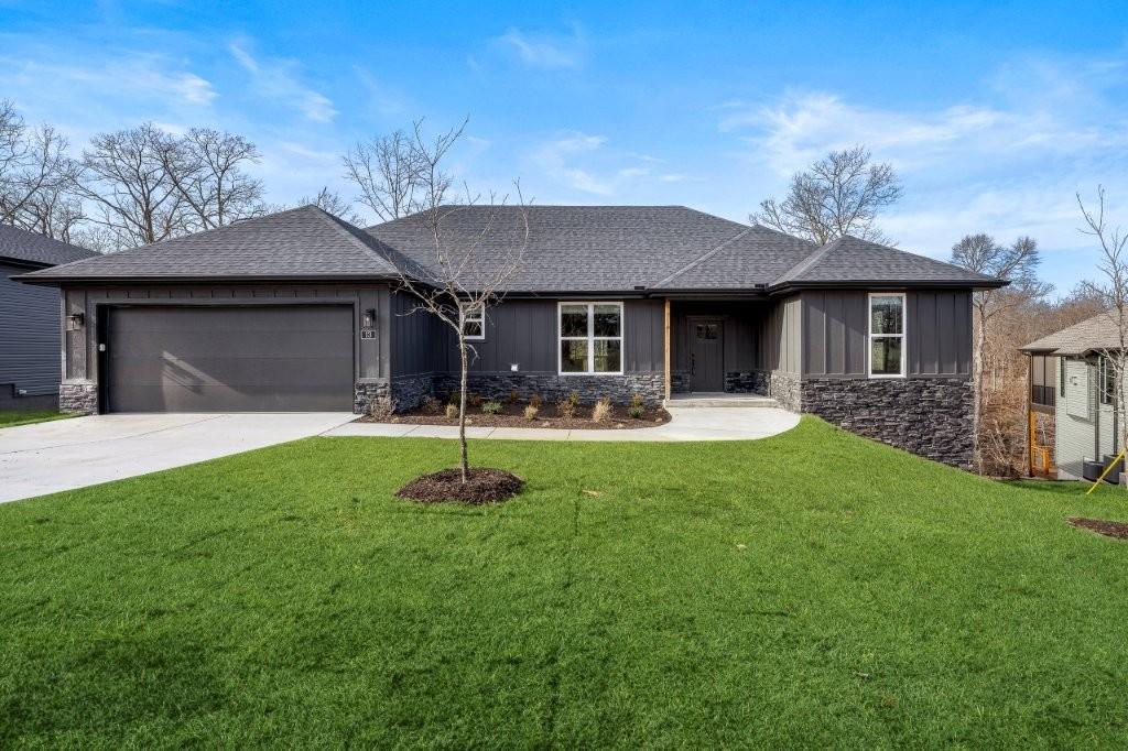 Image 1: Single story home with stone siding, a shingled ro