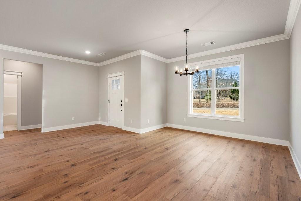 Image 3: Entryway with a chandelier, light wood-style floor
