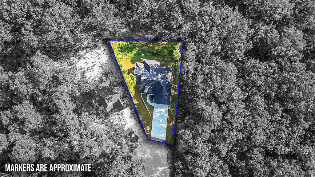 Image 3: Gable roofline residence with a driveway and surro