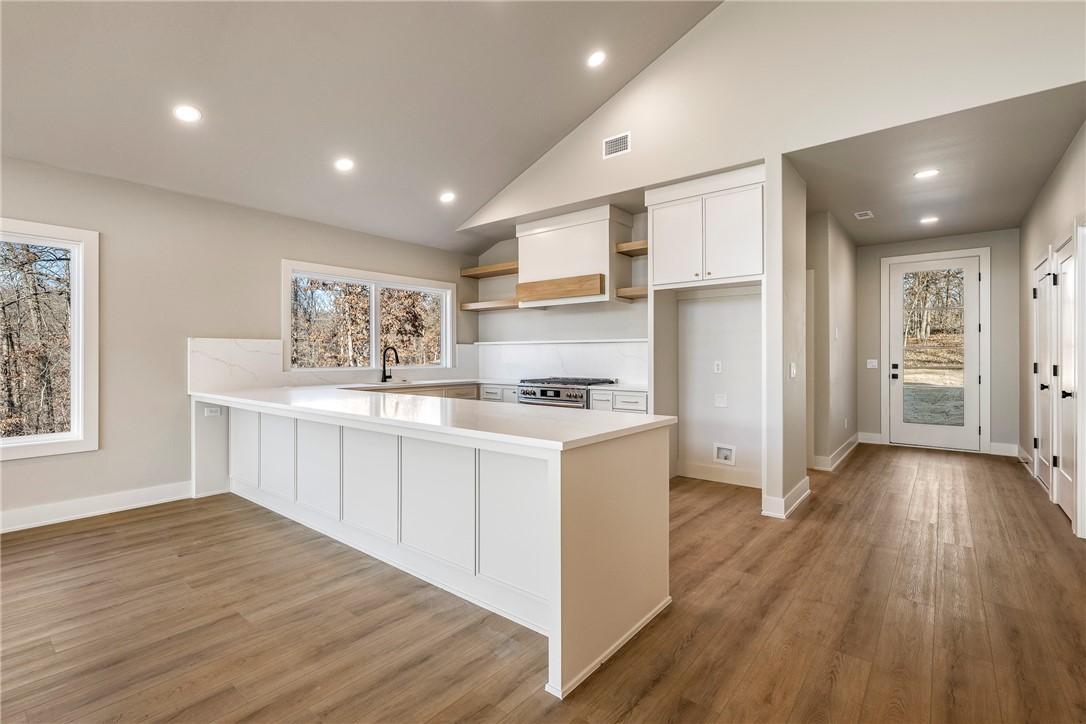Image 4: Kitchen featuring open shelves, a peninsula, light