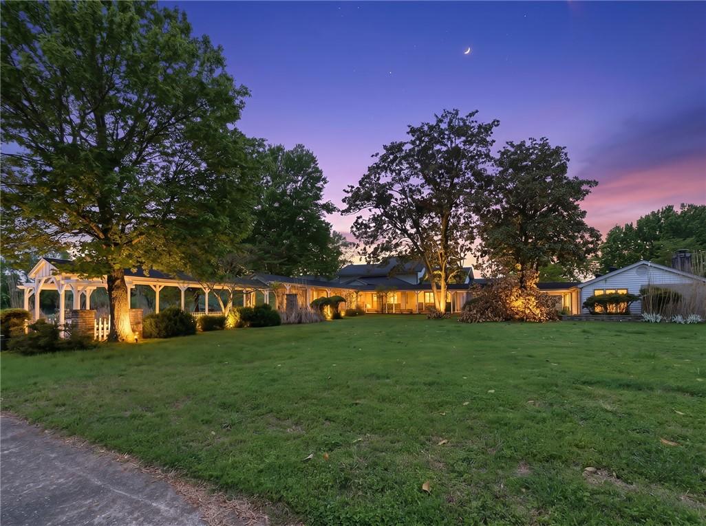 Image 4: Expansive front lawn with mature trees and a long,