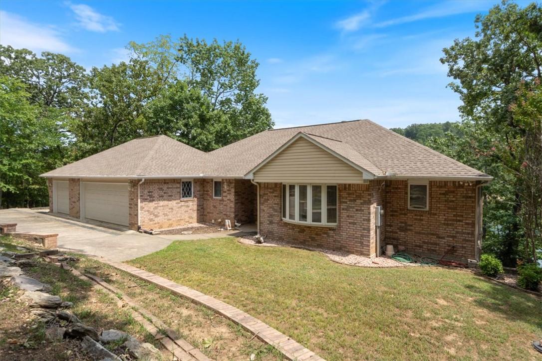 Image 3: Brick exterior with a 3-car garage, bay window, an