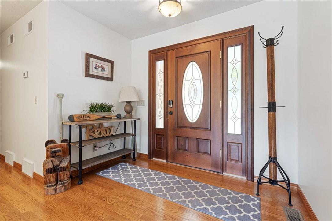 Image 4: Wood flooring, white wall paint, and a wood entry