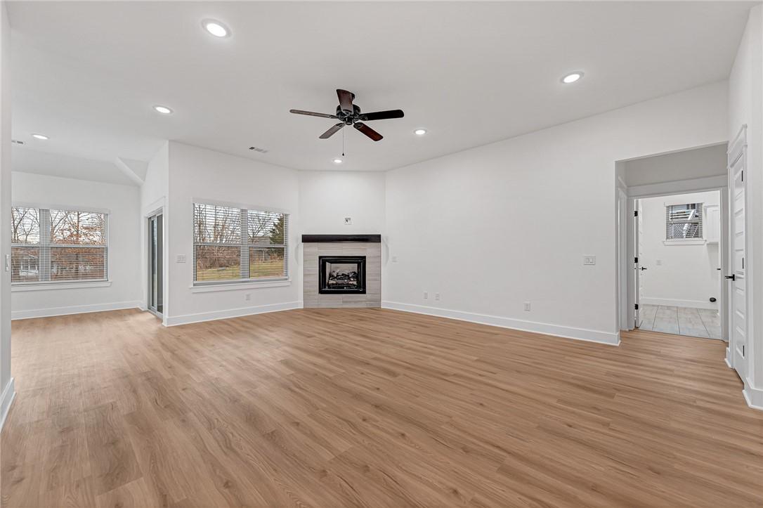 Image 3: Unfurnished living room featuring a tile fireplace