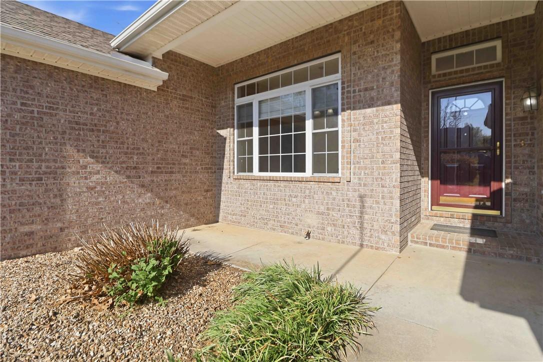 Image 4: Property entrance featuring brick siding and a pat