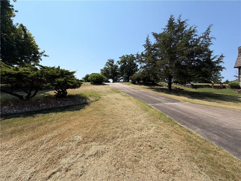 Image 4: Paved driveway ascending a gentle incline, flanked