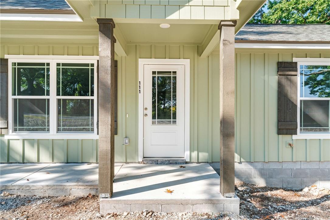 Image 3: Doorway to property featuring board and batten sid