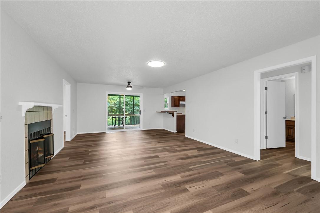 Image 2: Spacious living area featuring wood-finish floorin