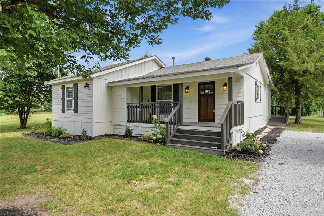 Image 2: White siding exterior with a dark wood entry door,