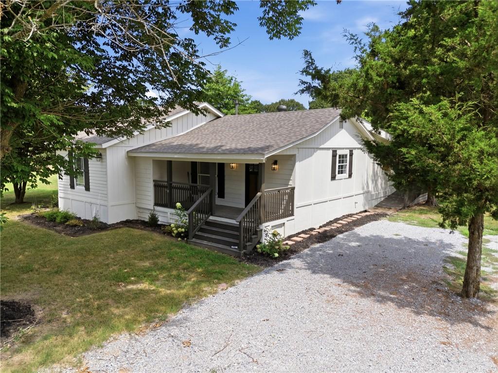 Image 3: White siding exterior with a dark shingle roof and
