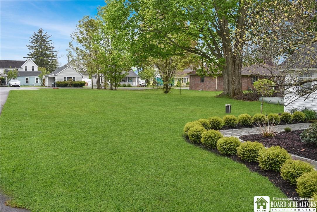 Image 4: Beautiful, maintained yard with lush lawn, mature