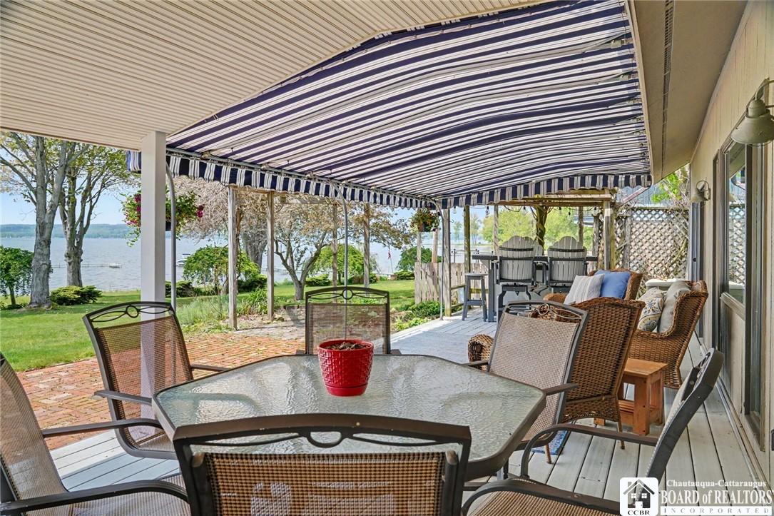 Image 3: Covered lakeside deck with outdoor dining and stun