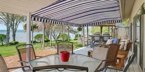 Image 3: Covered lakeside deck with outdoor dining and stun