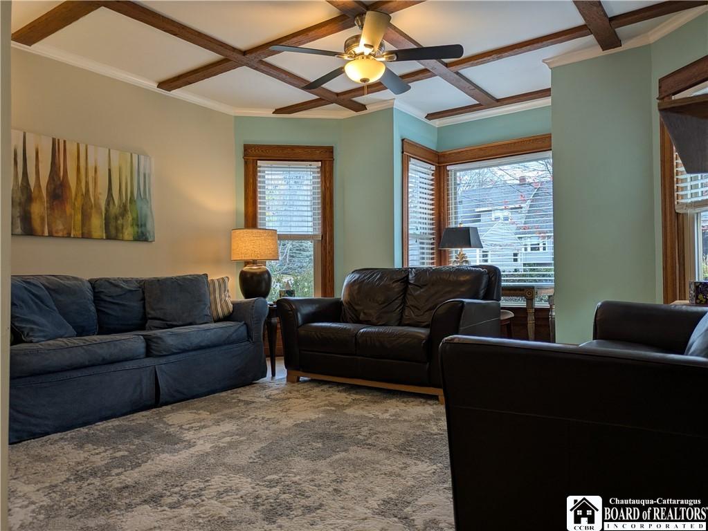 Image 3: Living room has oak flooring and windows across th