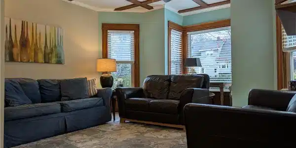 Image 3: Living room has oak flooring and windows across th