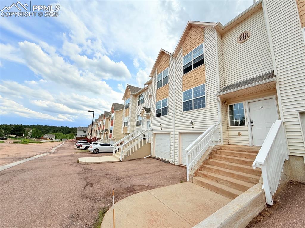 Image 1: View of property featuring driveway and an attached garage