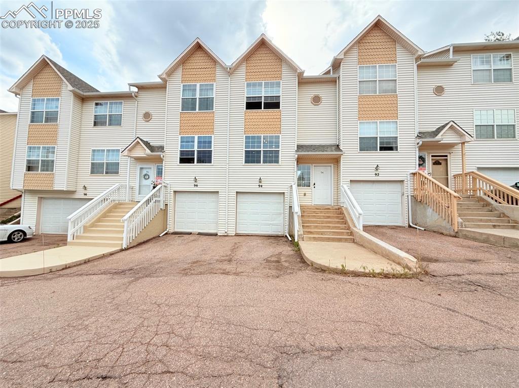 Image 3: View of front facade featuring asphalt driveway and a garage