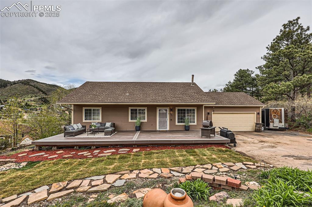 Image 1: Front view of house with an attached garage, concrete driveway, an outdoor hangout area, and a yard