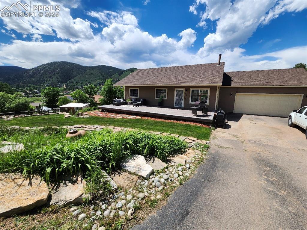 Image 4: Single story home featuring driveway, a deck with mountain view, and a garage