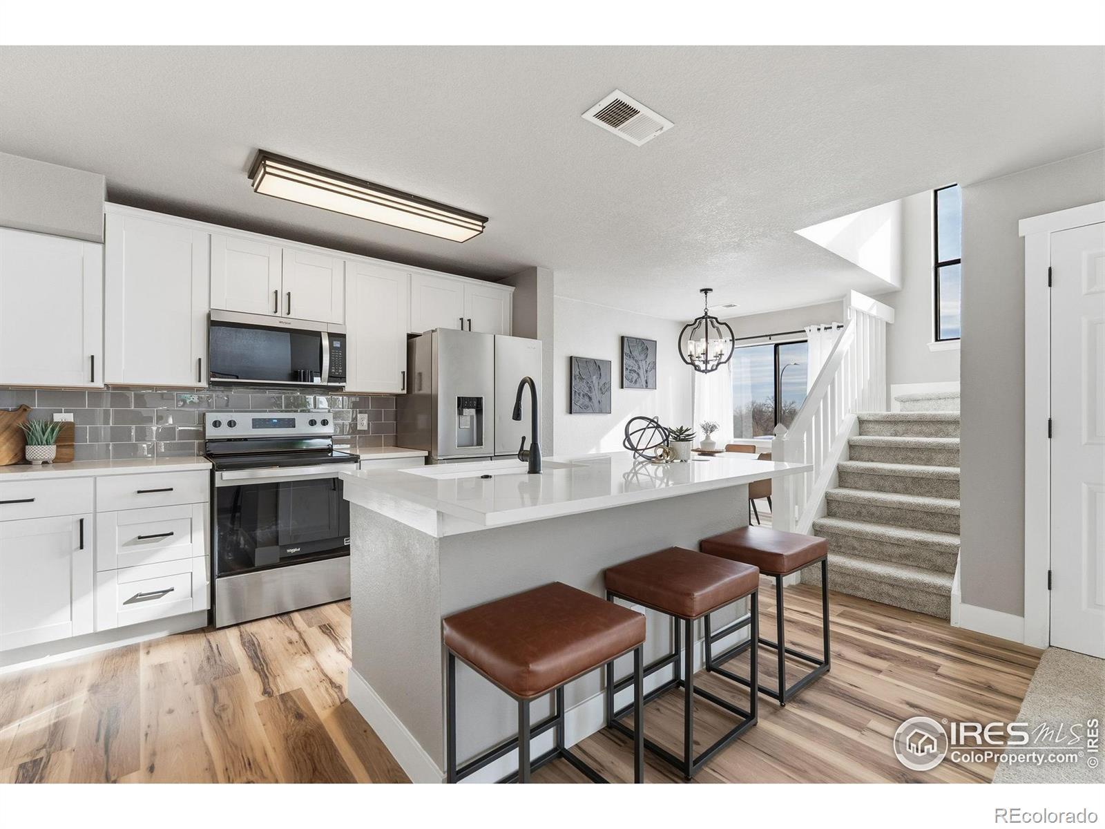 Image 2: Sleek new kitchen: quartz counters, modern cabinets & appliances.