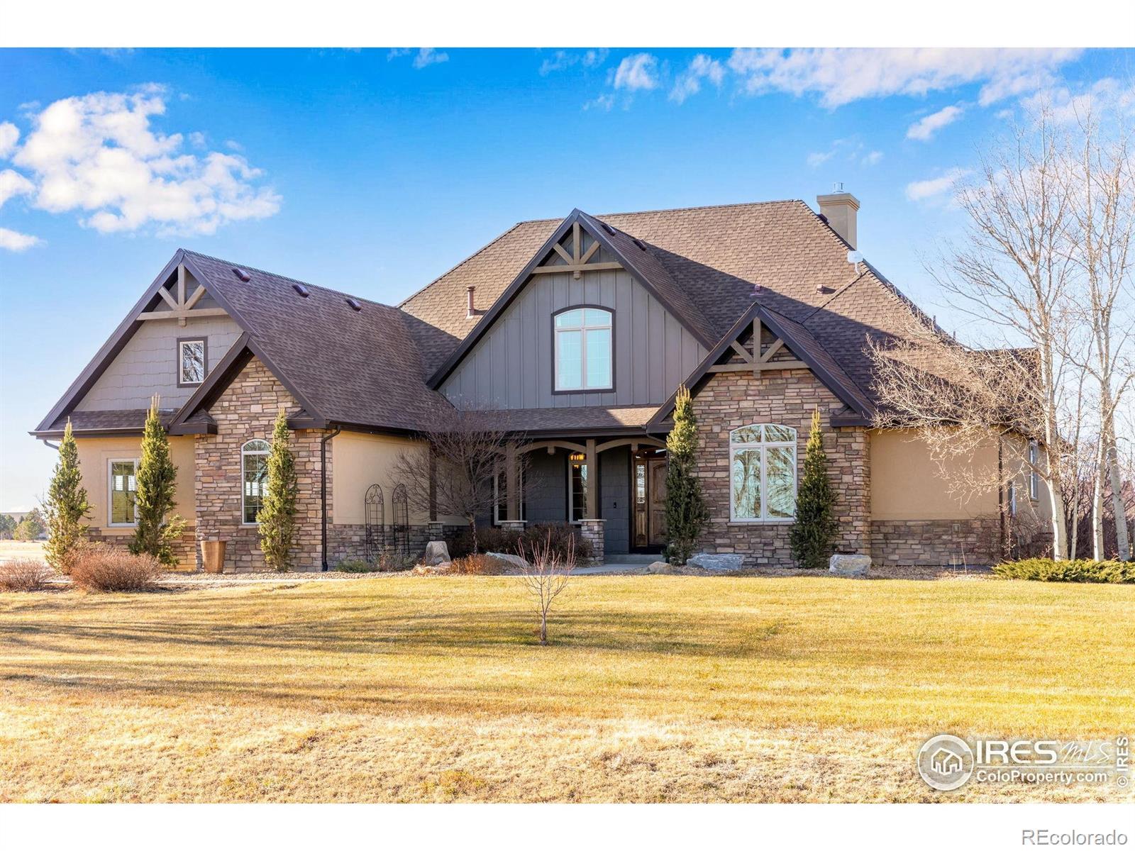 Image 3: Inviting front entry with covered porch, stone accents, timber details, mature landscaping, and timeless curb appeal.